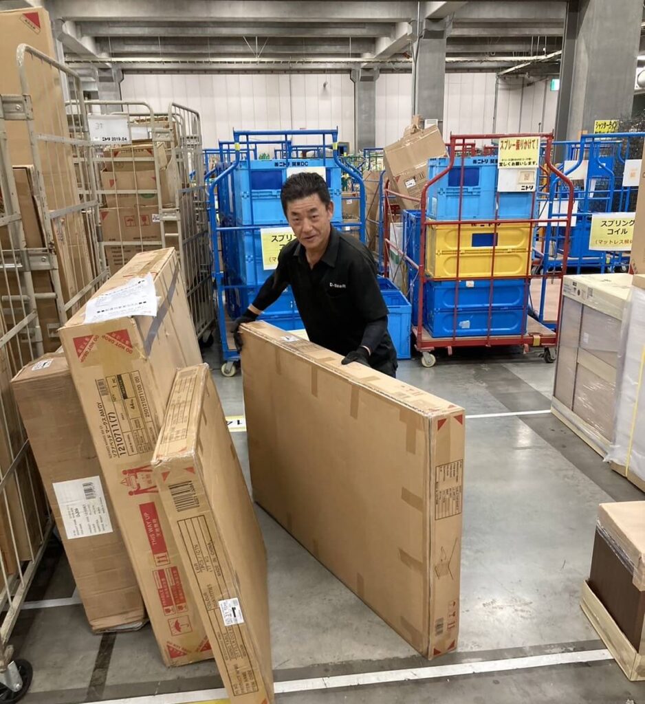 倉庫から荷物を運ぶ社員の写真